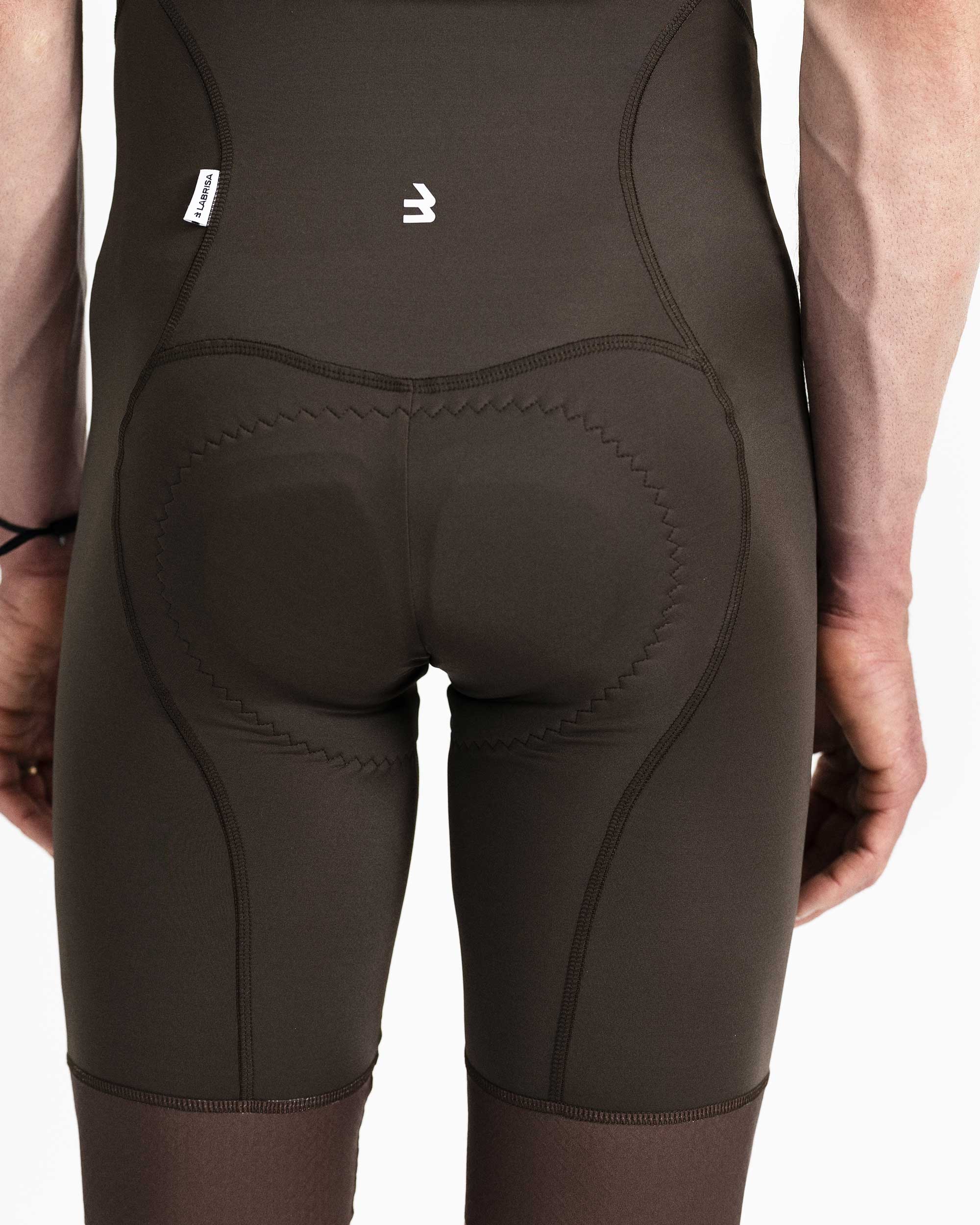 Imagen de culotte de ciclismo de hombre marrón por detrás. Se ve el detalle del isotipo en blanco de B de cerca situado en el centro encima de la badana. También se ve la badana.