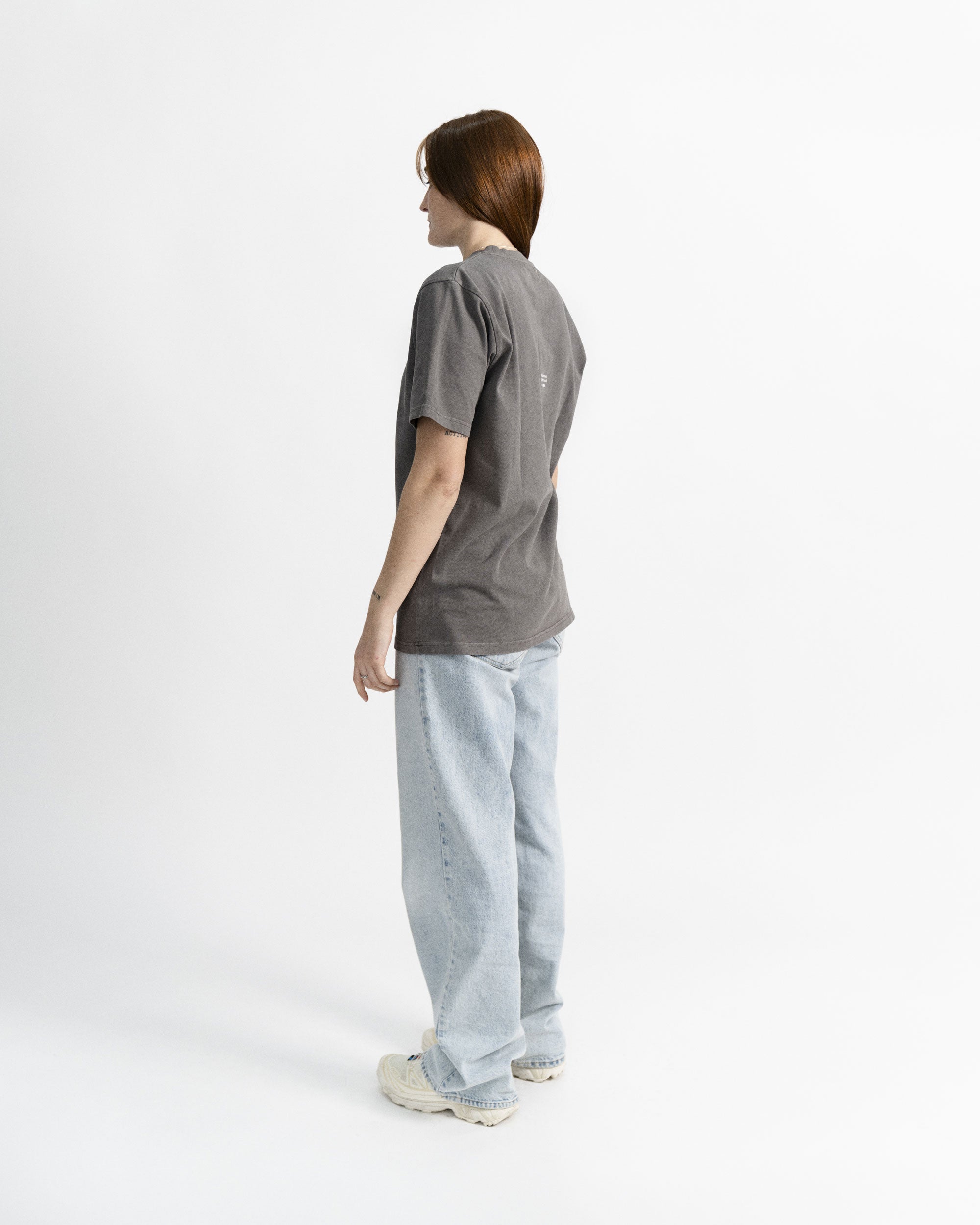 Imagen de la camiseta de manga corta gris en modelo visto desde el perfil izquierdo.