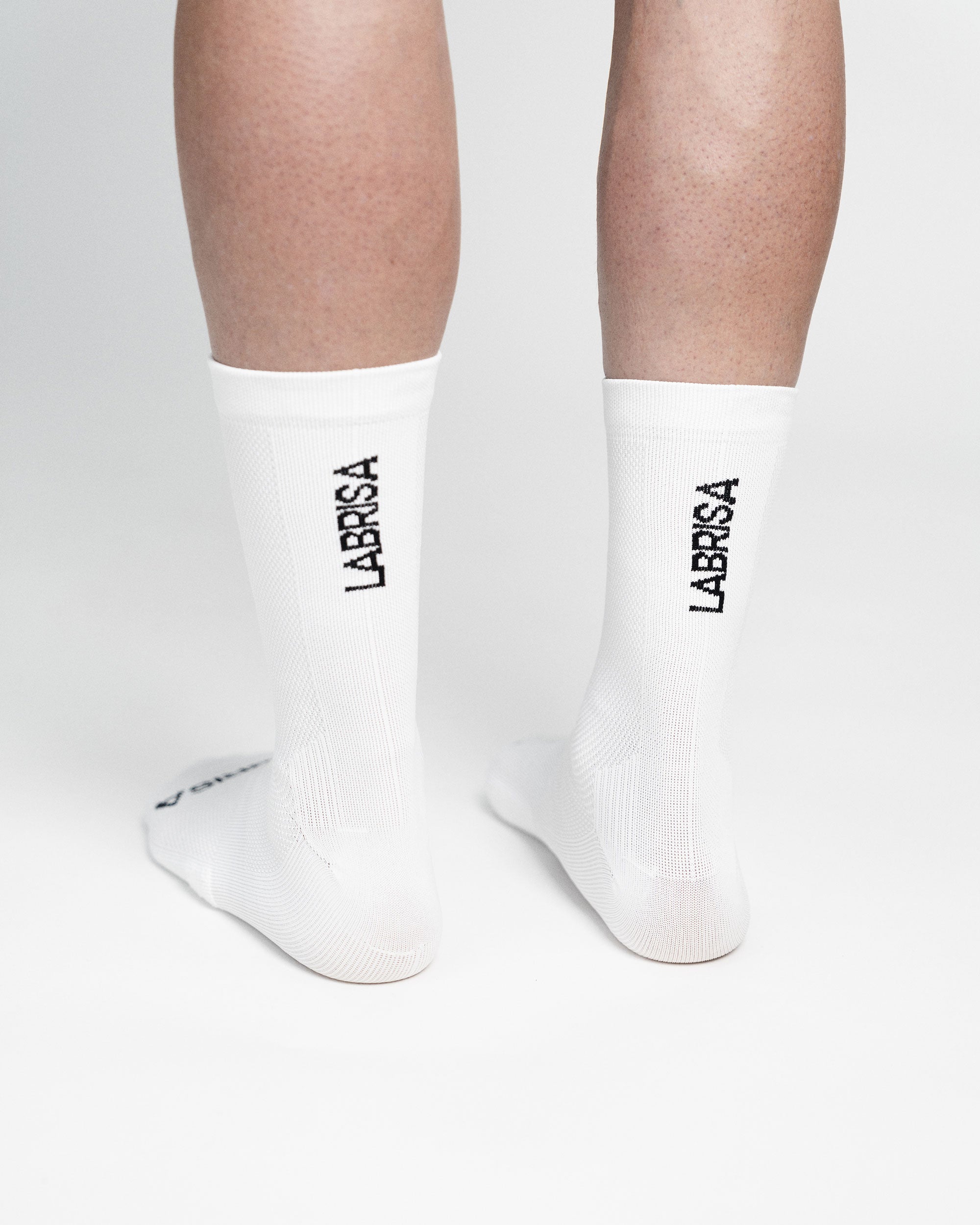 Imagen trasera de la caña de calcetines de ciclismo blancos en la que se lee en negro LABRISA
