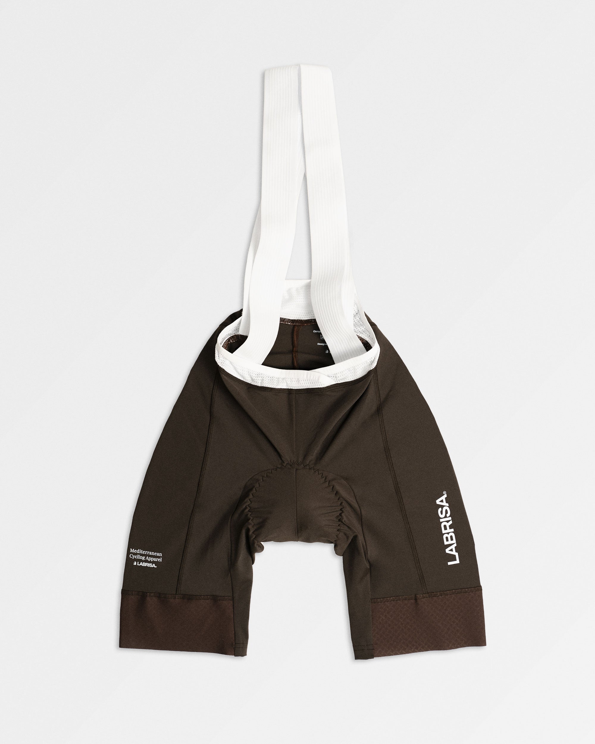 Imagen de culotte de ciclismo de mujer marrón. Logotipos en blanco de LABRISA en la pierna izquierda y el tagline de Mediterranean Cycling Apparel en la derecha. Los tirantes son blancos y el vivo son blancos.