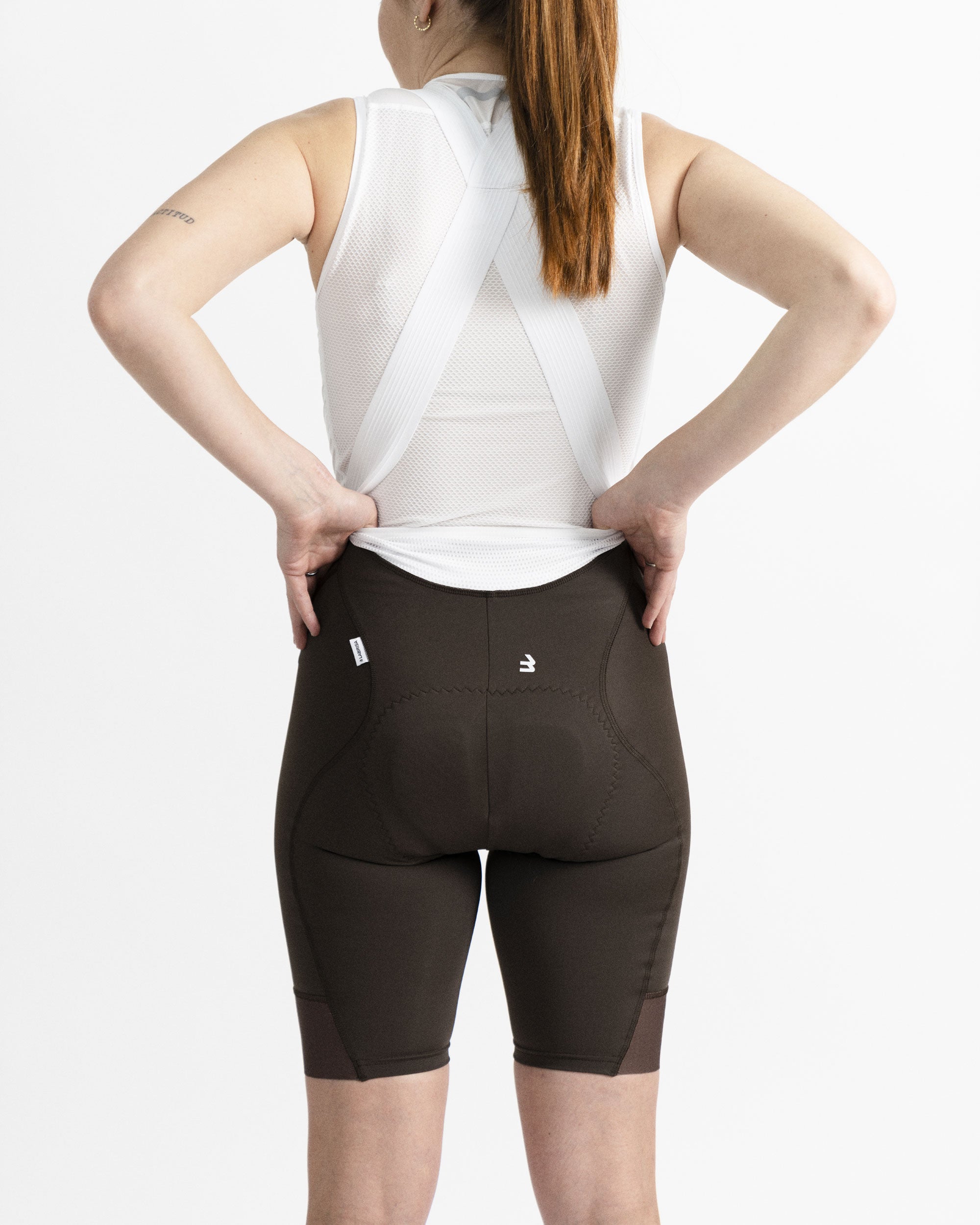 Imagen del culotte de ciclismo de mujer marrón. Se muestra como el culotte está diseñado para poder hacer pis sin tener que bajar los tirantes ni quitar el maillot.