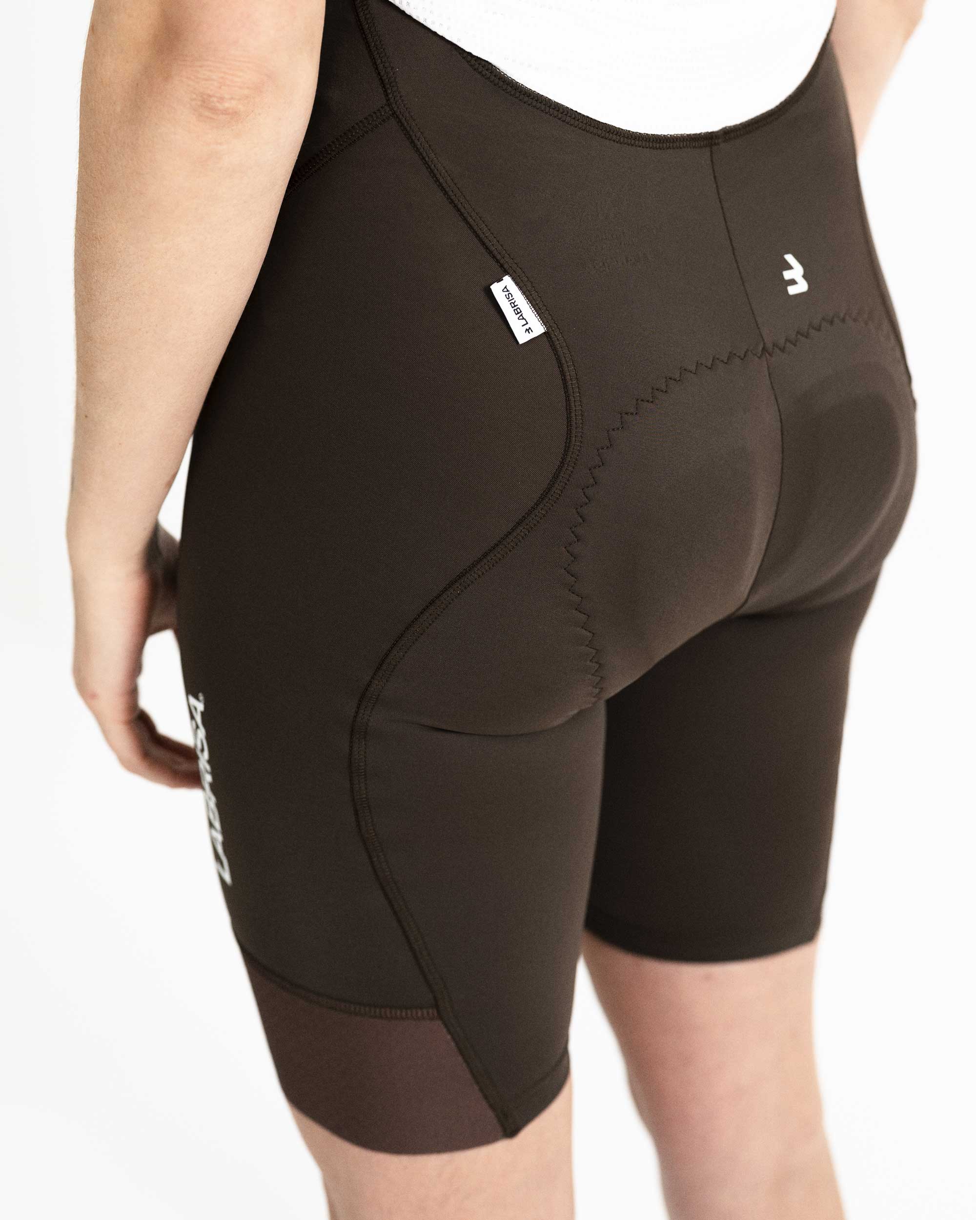 Imagen de culotte de ciclismo de mujer marrón por detrás. Se ve el detalle de la etiqueta tejida cosida en el lateral izquierdo. La etiqueta es blanca con LABRISA escrita en negro