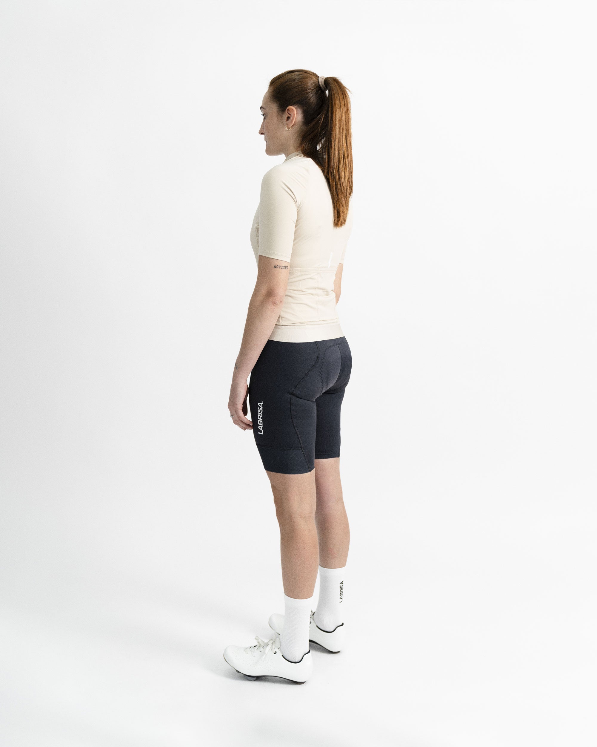 Imagen de maillot de ciclismo de mujer crema en modelo visto desde el perfil izquierdo.