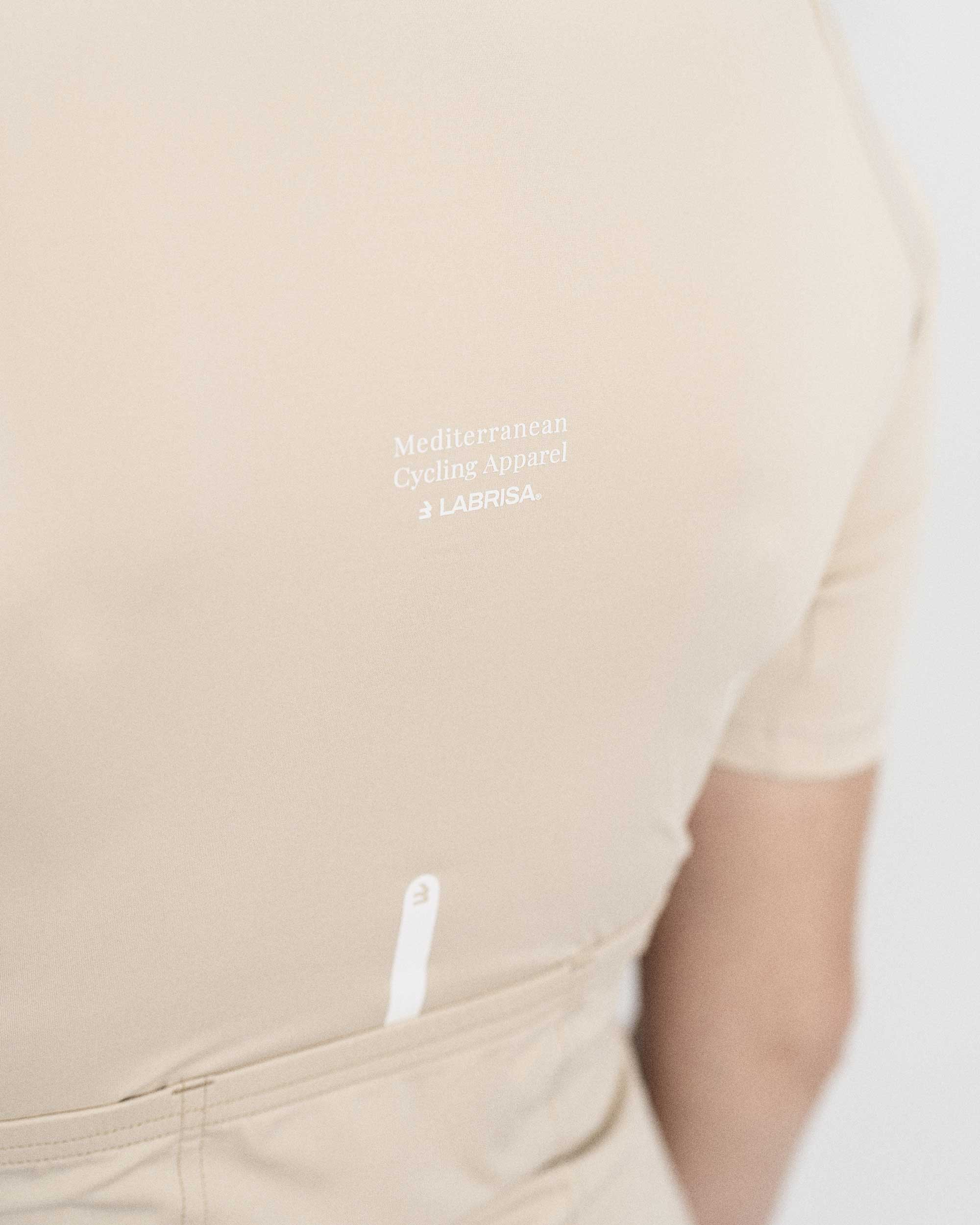 Imagen de detalle de maillot de ciclismo de mujer crema de la parte trasera. Se puede ver el detalle de Mediterranean Cycling Apparel en el centro de la espalda.