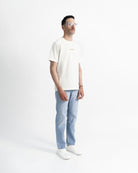 Imagen de la camiseta de manga corta crema en modelo visto desde el perfil derecho.