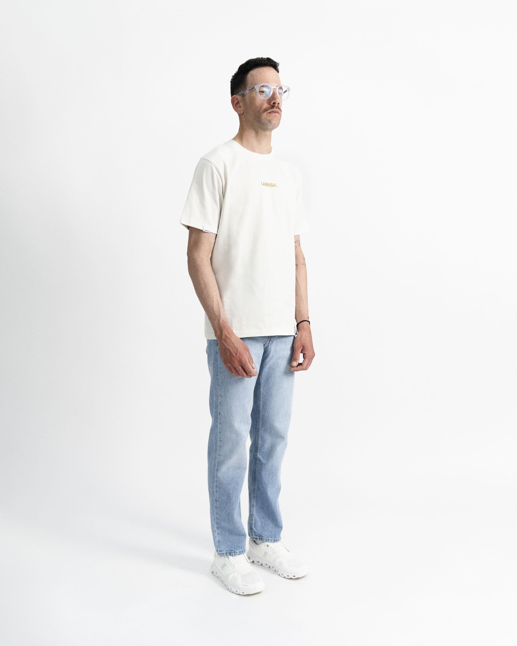 Imagen de la camiseta de manga corta crema en modelo visto desde el perfil derecho.