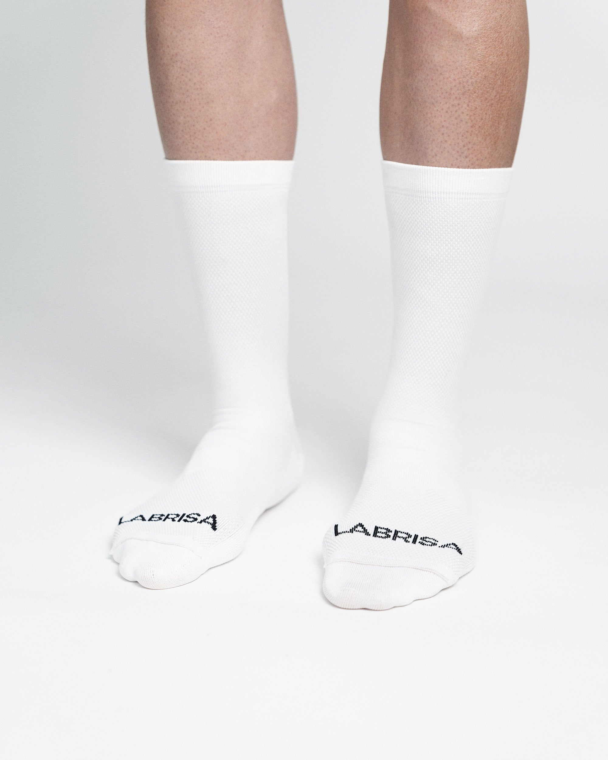 Imagen de delantera de calcetines  de ciclismo blancos en la que se lee en la puntera en negro LABRISA 