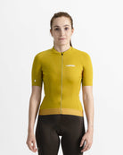 Imagen de maillot de ciclismo de mujer  verde oliva en modelo visto de frente. Logotipo de LABRISA en blanco en el pecho izquierdo e isotipo en blanco de la B en el bíceps derecho. Cremallera, siliconas y demás detalles al mismo tono verde oliva. 